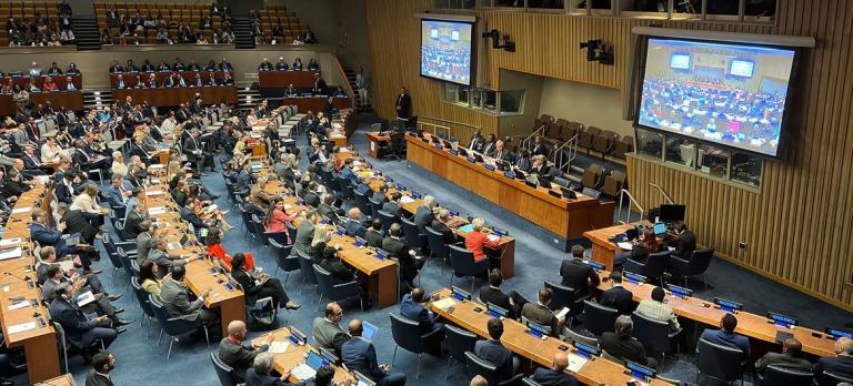 A large room with many people sitting at desks.