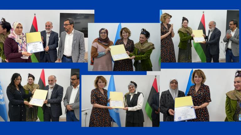 People at a certificate ceremony, receiving awards from presenters. Background includes flags from different countries.