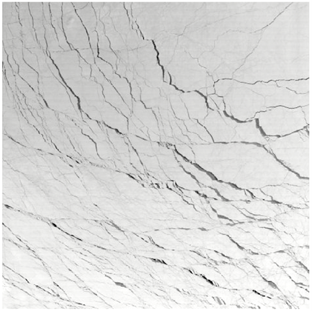 Close-up of a cracked, white marble surface with intersecting lines forming irregular patterns across the entire image.