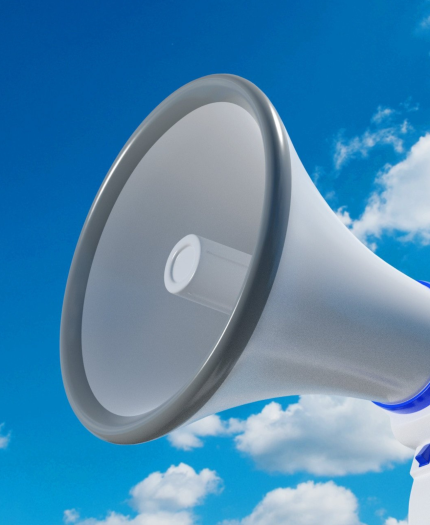 Close-up of a blue and white megaphone facing left against a clear sky with scattered clouds.